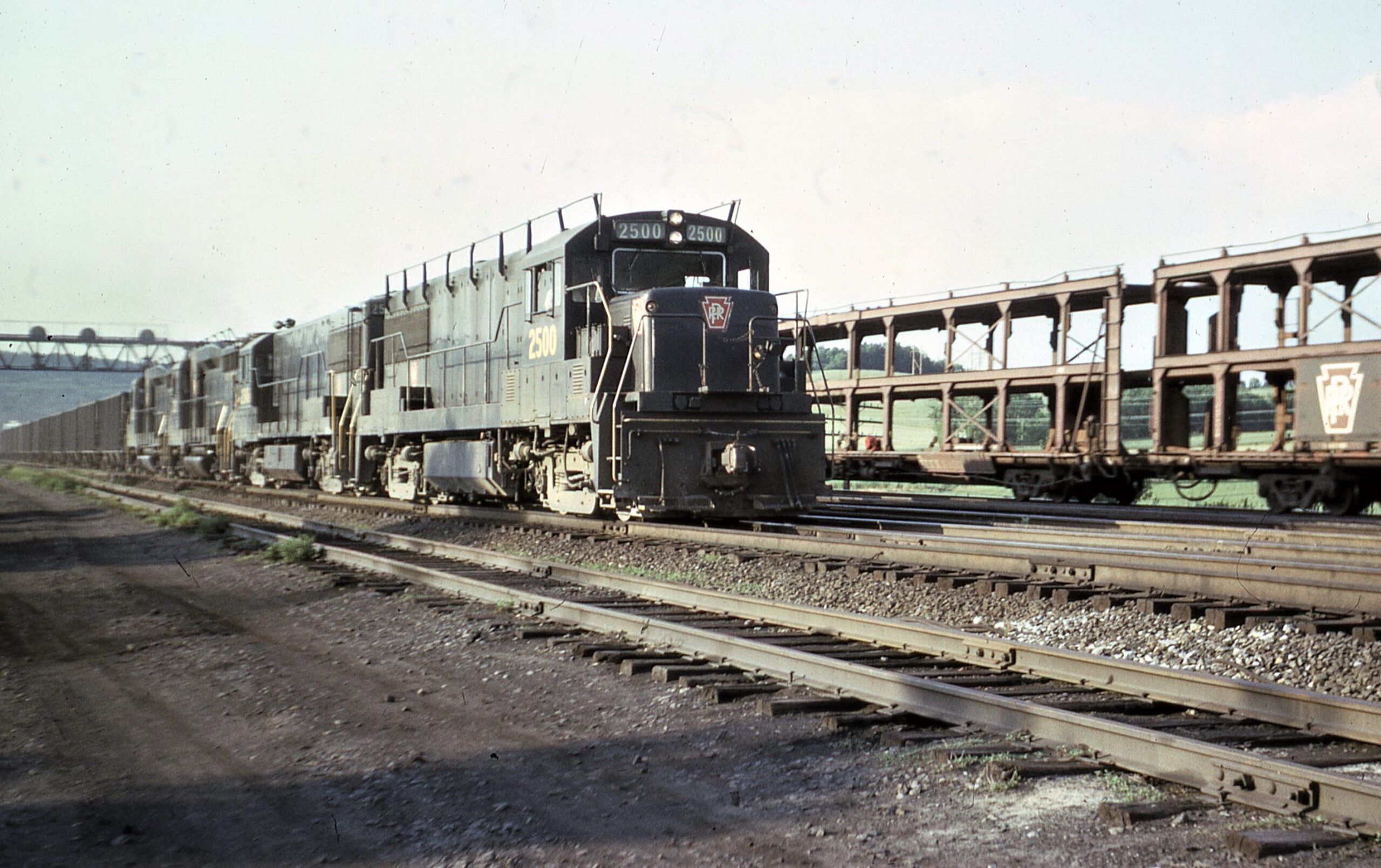 Pennsylvania Railroad | Lewistown, Pennsylvania | GE Class U25B #2500 + 1 + 2 EMD GP30 diesel-electric locomotives | Coal train | PRR Auto Rack train | June, 1966 | Dick Flock photograph