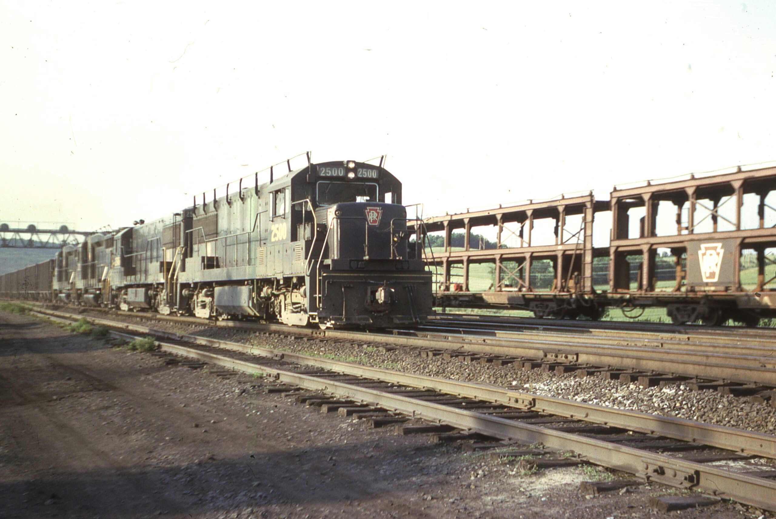 Pennsylvania Railroad | Lewistown, Pennsylvania | GE Class U25B #2500 + 1 + 2 EMD GP30 diesel-electric locomotives | Coal train | PRR Auto Rack train | June, 1966 | Dick Flock photograph