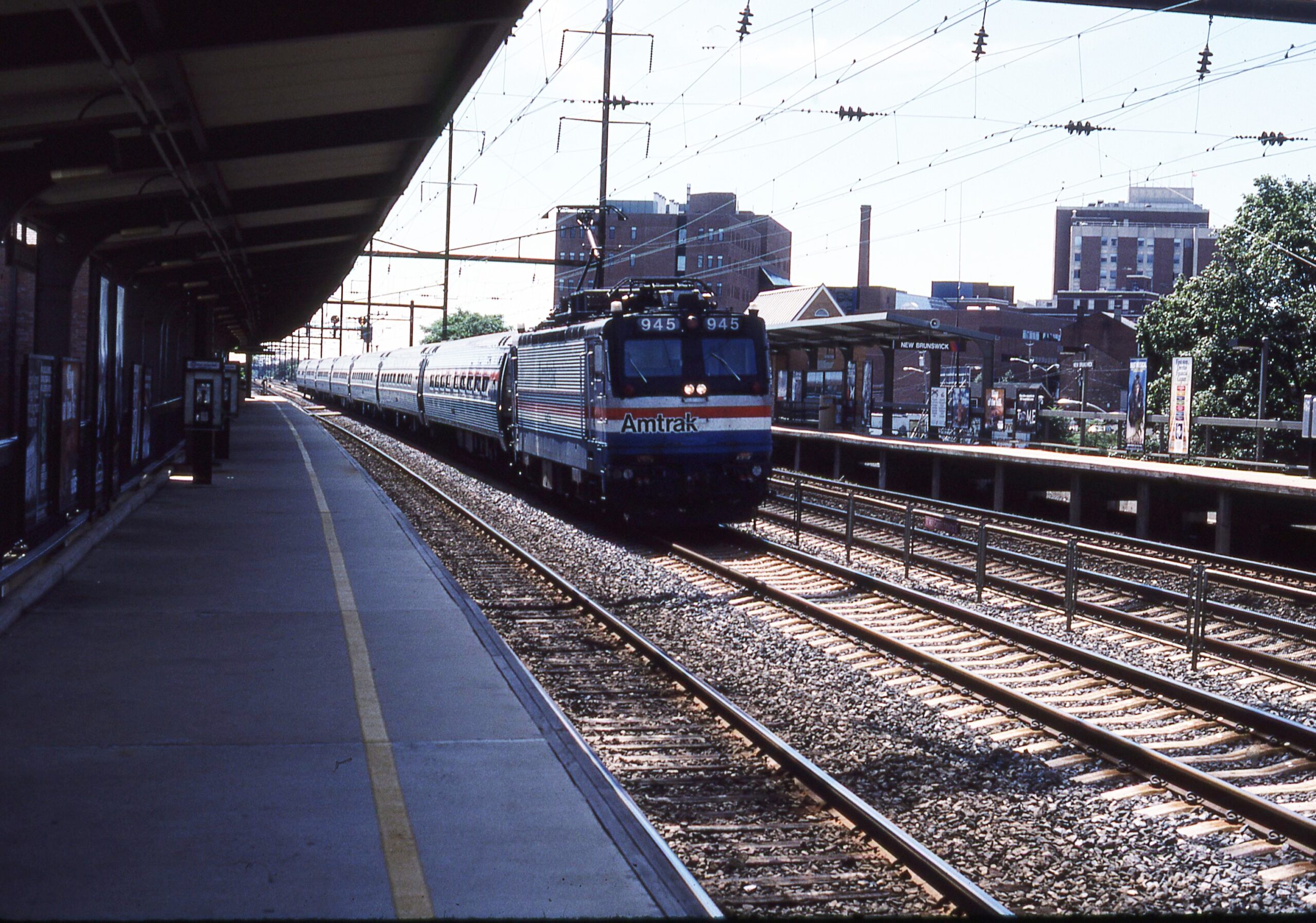 Amtrak | New Brunswick, New Jersey | EMD AEM-7 #945 electric motor | Train #140 | eastbound passenger train | New Brunswick, N.J. station | August 26, 1984 | Richard Prince photograph