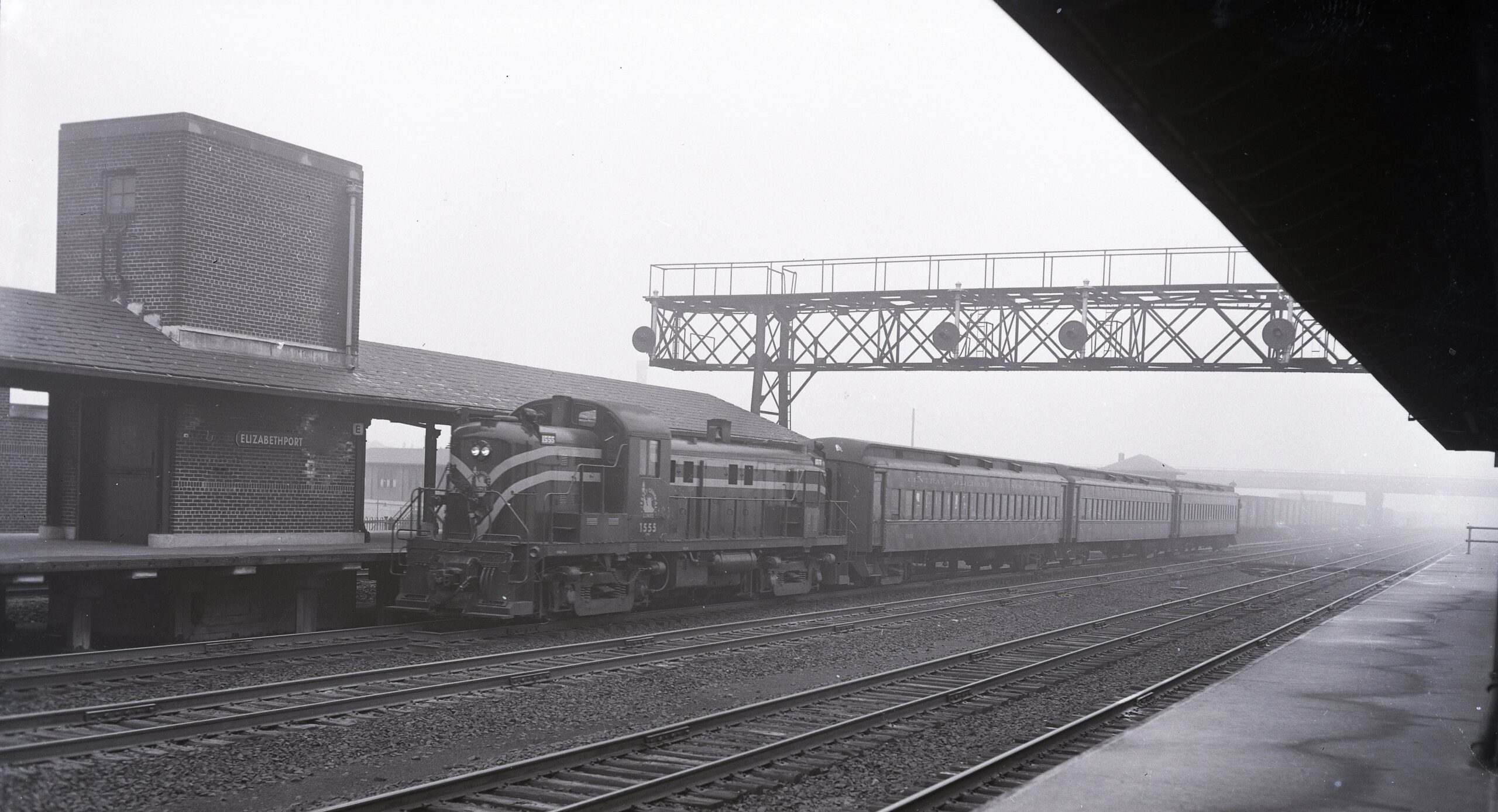 Central Railroad of New Jersey | Elizabethport, New Jersey | Alco class RS3 # 1555 | Local eastbound Commuter Train | Elizabethport Passenger Station | May 17, 1953 | Robert Long photograph | West Jersey Chapter Collection