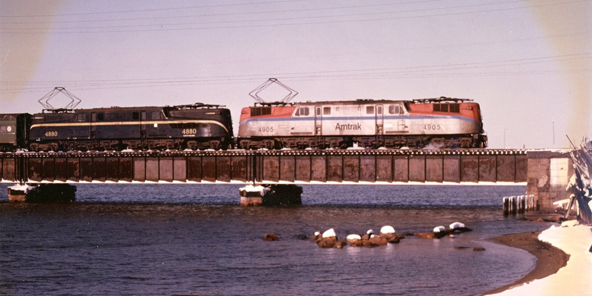 Amtrak | Perth Amboy, New Jersey | Raritan Bay Bridge | Altoona Works Class GG1 #4905 and NJDOT GG1 #4880 electric motors | eastbound passenger commuter train | February 1980 | Walter Grosselfinger photograph