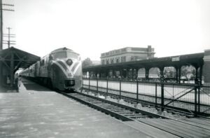Central Railroad of New Jersey | New York and Long Branch Railroad | Asbury Park, New Jersey | Baldwin DRX-6-4-2000 #2003 diesel-electric locomotive | Westbound commuter train | Asbury Park Passenger station | July 6, 1953 | Howard Johnston photograph | North Jersey Chapter, NRHS Collection
