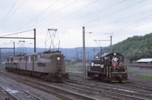 Penn Central Transportation Company | ex Pennsylvania Railroad | Enola, Pennsylvania | Altoona Works dirty GG1 and EMD SW1 #8557 diesel-electric, fresh paint, locomotive | June 1969 | Ken Kulick photograph / collection