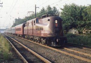 New Jersey Transit | ex Pennsylvania Railroad | New York and Long Branch | South Amboy, New Jersey | Altoona Works Class GG1 #4877 electric motor | Eastbound Bay Head, NJ to New York City commuter train | July 1983 | Frank Etzel photograph / collection