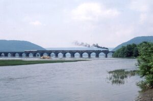Pennsylvania Railroad | Strasburg Railroad | Conrail | Rockville, Pennsylvania | Juniata Works Class E7 4-4-2 #1223 and D16sb 4-4-0 #1223 steam locomotives | NRHS Convention Steam Special | Rockville Bridge | August 1985 | Mitchell E. Dakelman photograph / collection